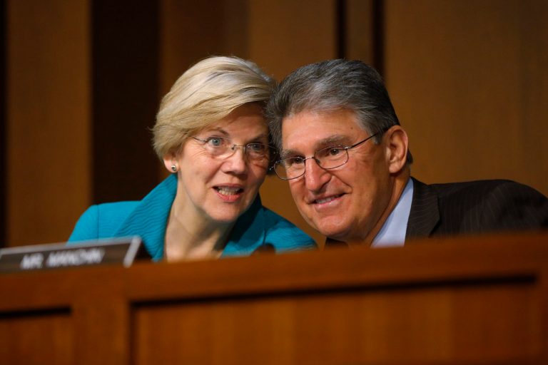 Senate Banking Committee member Sen. Elizabeth Warren, D-Mass., left, and Sen. Joe Manchin, D-W.Va., talk on Capitol Hill in Washington, Wednesday, June 25, 2014, during the committee's hearing with Treasury Secretary Jack Lew to examine the Financial Stability Oversight Council annual report to Congress. (AP Photo/Charles Dharapak)
