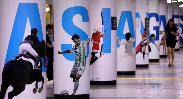 A woman passes by 2014 Asian Games posters at a subway station in Seoul, South Korea, Friday, July 18, 2014. North Korea threatened Friday to review its decision to enter the upcoming Asian Games in South Korea, a day after their talks on the games broke down. (AP Photo/ Lee Jin-man)