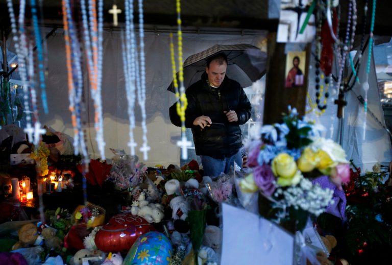   Ben Toby of Sandy Hook visits a memorial to the Newtown shooting victims during a heavy rain in the Sandy Hook village of Newtown, Conn., Friday, Dec. 21, 2012. The shooter, Adam Lanza, walked into Sandy Hook Elementary School in Newtown, Dec. 14, and opened fire, killing 26 people, including 20 children, before killing himself.Â  (AP Photo/Seth Wenig)  