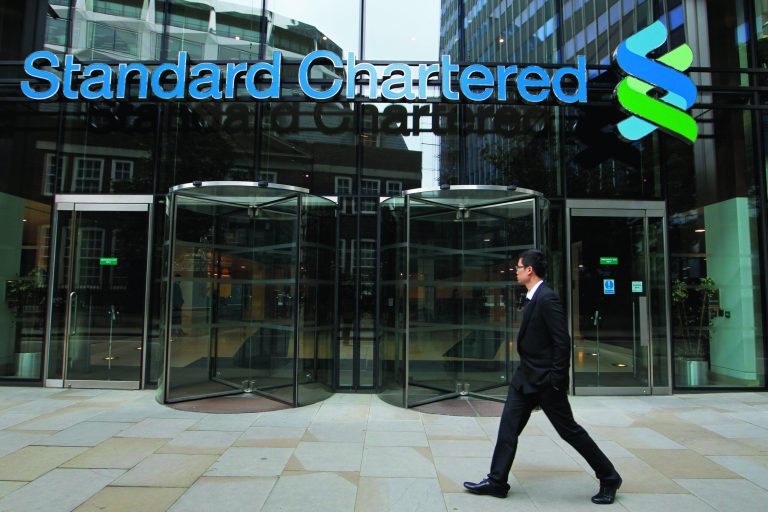 A man walks by the headquarter of Standard Chartered bank in the City of London, Tuesday, Aug. 7, 2012. Shares in Standard Chartered PLC dropped sharply on Tuesday as investors reacted to U.S. charges that the bank was involved in laundering money for Iran. The charges against Standard Chartered were a shock for a bank which proudly described itself recently as 