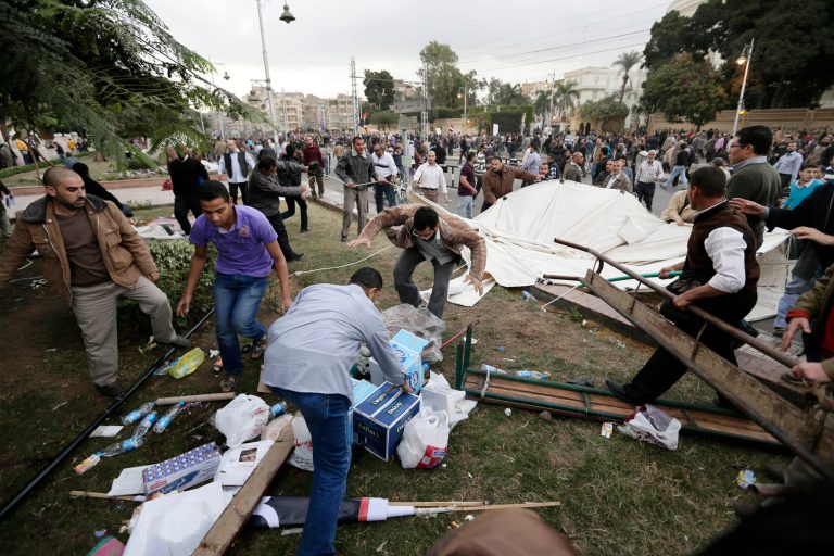  FILE - In this Wednesday, Dec. 5, 2012 file photo, supporters of Egyptian President Mohammed Morsi remove tents of opposition protesters outside the presidential palace, in Cairo, Egypt. The scene from bloody clashes outside the presidential palace a week ago hangs over Egypt's political crisis, as a daunting sign of how much more violent the confrontation between Morsi's Islamist supporters and the opposition that has launched a giant wave of protests against him can become. (AP Photo/Hassan Ammar, File)  