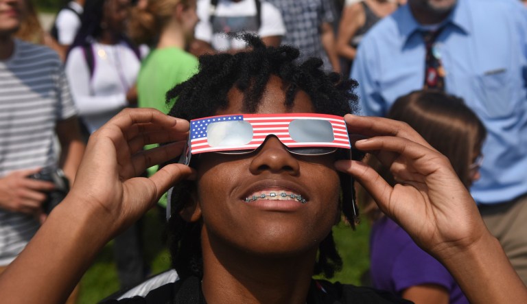 Cheyanne Farmer, Philadelphia, Pa., watches the solar eclipse through solar eclipse glasses during a viewing event for the solar eclipse at Penn State Schuylkill Campus in Schuylkill Haven, Pa., on Monday, August 21, 2017. (Jacqueline Dormer/The Republican-Herald via AP)