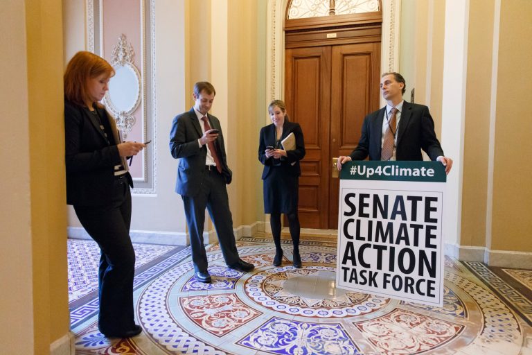 Joe Mendelson, the majority chief climate counsel with the Senate Committee on Environment, right, and other Senate staffers, wait outside the Senate chamber on Capitol Hill in Washington, Tuesday, March 11, 2014, as Democratic senators finish an all-night session warning of devastation from climate change and the danger of inaction. (AP Photo/J. Scott Applewhite)