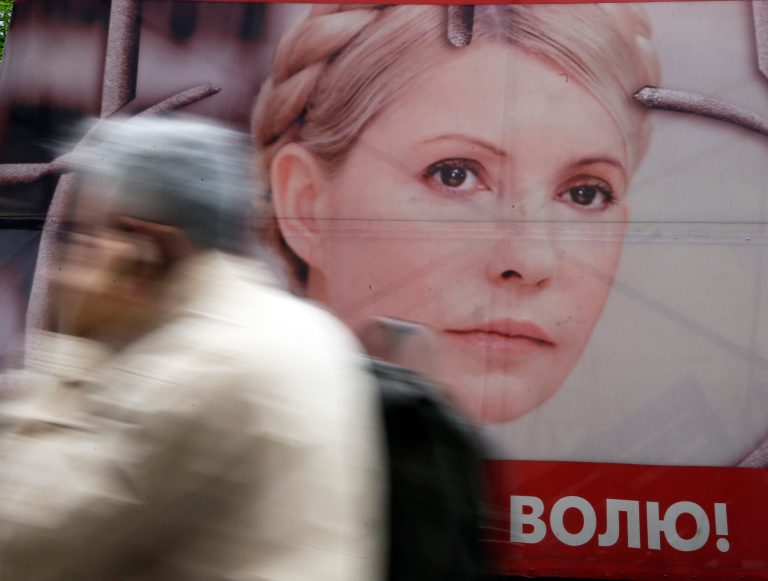 A man pass by a posters of Ukraine's imprisoned former Prime Minister Yulia Tymoshenko decorating a tent camp of her supporters in central Kiev, Ukraine, Tuesday, April 30, 2013. Europe's human rights court in Strasbourg, France, ruled Tuesday that Ukraine's jailing of former Prime Minister Yulia Tymoshenko was a politically motivated violation of her rights, but it is unclear if the European court ruling would be legally binding in Ukraine. The poster with Tymosneko reads 