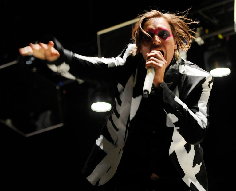FILE - In this April 13, 2014 file photo, Win Butler of Arcade Fire performs during their headlining set on the third day of the 2014 Coachella Music and Arts Festival in Indio, Calif. Internet radio leader Pandora has come to its first-ever direct licensing deal with artists, a wide-ranging agreement with independent label group Merlin, who represents Arcade Fire, that both said would mean higher payments to artists and more play for them on Pandora stations. (Photo by Chris Pizzello/Invision/AP, File)