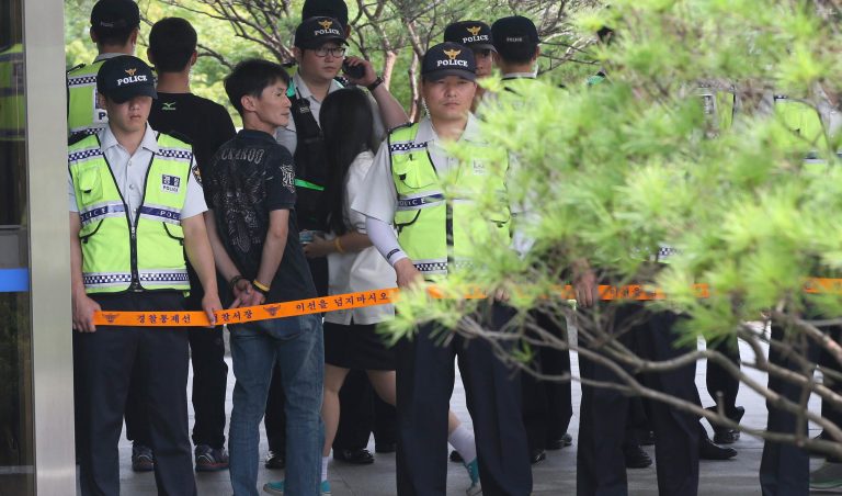 A survivor student from the sunken ferry Sewol in the water off the southern coast arrives to testify in the trial of the 15 crew members as police officers stand guard outside of the Ansan branch of Suwon District Court in Ansan, South Korea, Monday, July 28, 2014. South Korean students who survived April's deadly ferry disaster say they were repeatedly ordered by loudspeaker to stay in the sinking ship but eventually helped each other flee after their cabins were flooded too much. (AP Photo/Shin Young-keun, Yonhap) KOREA OUT