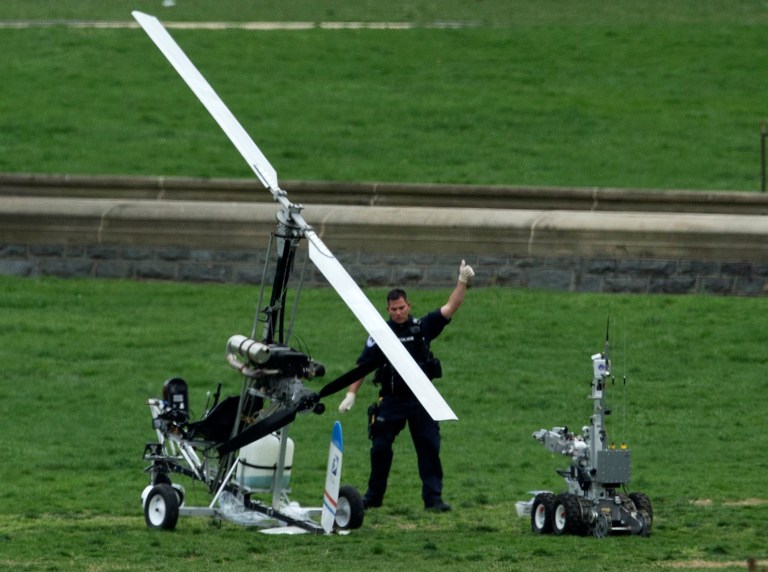 A Capitol Police officer flashes a thumbs up after inspecting the small helicopter a man landed on the West Lawn of the Capitol in Washington, Wednesday, April 15, 2015. (AP Photo/Manuel Balce Ceneta)
