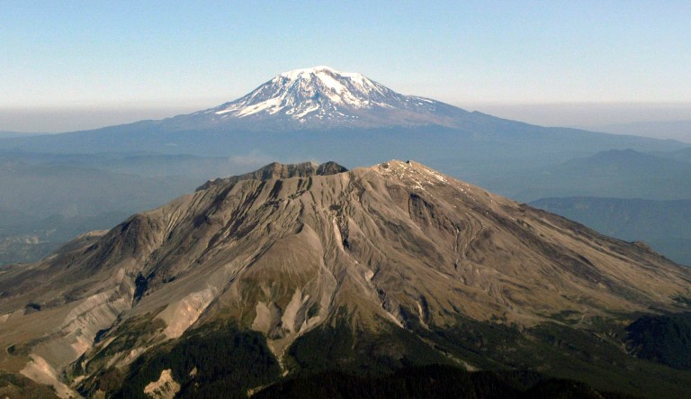 An aerial view of Mount St. Helens with Mt. Adams in the background is shown during an aerial tour of the mountain, Saturday, Oct. 2, 2004. A new study released Friday by the National Academies of Science says 50,000 lives would be in danger if the volcanic debris erodes and floods the nearby area. It recommends creating an updated plan to contend with the risks and examine options for upgrading, or adding, new infrastructure to avert a disaster. (AP Photo/Jeff T. Green)