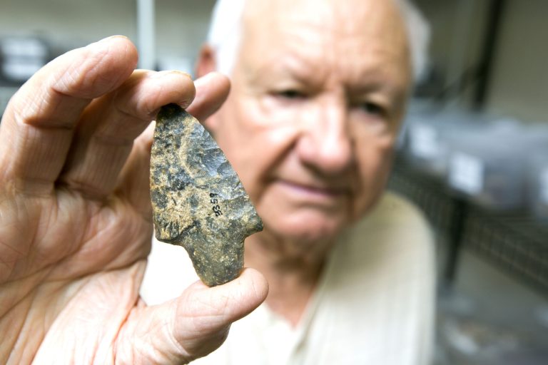 In a Tuesday July 22, 2014 photo, Alvin Hendrix shows the first arrow head he found when he began collecting from area rivers since the early 1960s in a store room at the Silver River Museum in Ocala, Fla. He donated those items to the  Museum where some are on display and others are tucked away in store rooms and vaults. Its now illegal to collect these items but wasn't at the time he began collecting.   (AP PhotoOcala Star-Banner, Alan Youngblood)