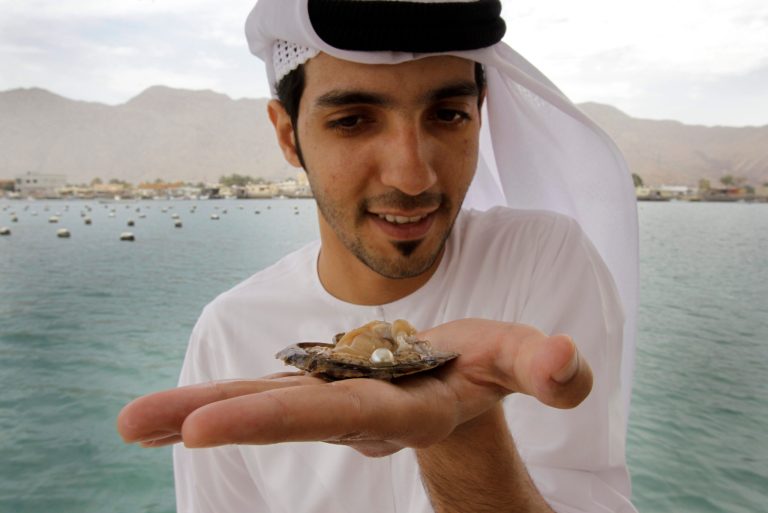   In this Wednesday, April 4, 2012 photo, Mohamed al-Suwaidi from RAK Pearls Holding holds a cultured pearl inside an oyster shell after they have collected it from the sea farm in Ras al-Khaimah, United Arab Emirates. Long before the discovery of oil transformed the Gulf, the region's pearl divers were a mainstay of the economy. Their way of life, however, also was changed forever after Japanese researchers learned how to grow cultured pearls in 1930s. Now a collaboration between pearl traders in Japan and the United Arab Emirates had brought oyster farming to the UAE for the first time. (AP Photo/Kamran Jebreili)  