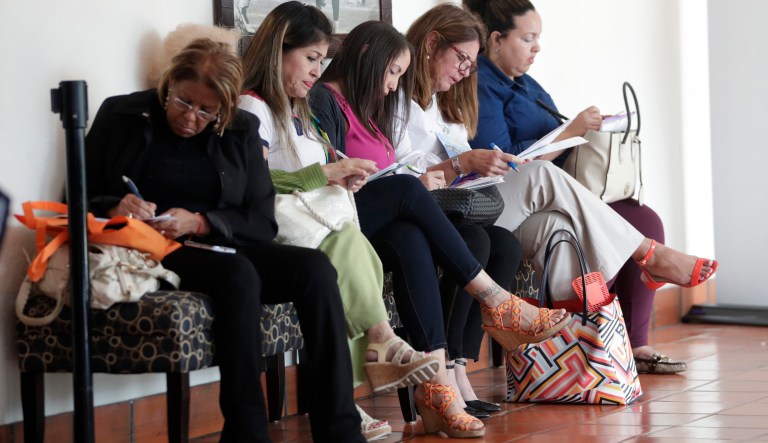In this Tuesday, Jan. 30, 2018, photo, women fill out job applications at a JobNewsUSA job fair in Miami Lakes, Fla. (AP Photo/Lynne Sladky)
