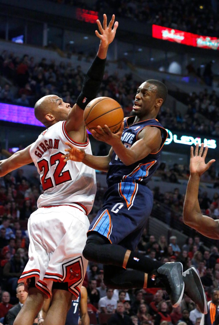   Charlotte Bobcats guard Kemba Walker (15) shoots past Chicago Bulls forward Taj Gibson (22) during the first half of an NBA basketball game Monday, Dec. 31, 2012, in Chicago. (AP Photo/Charles Rex Arbogast)  