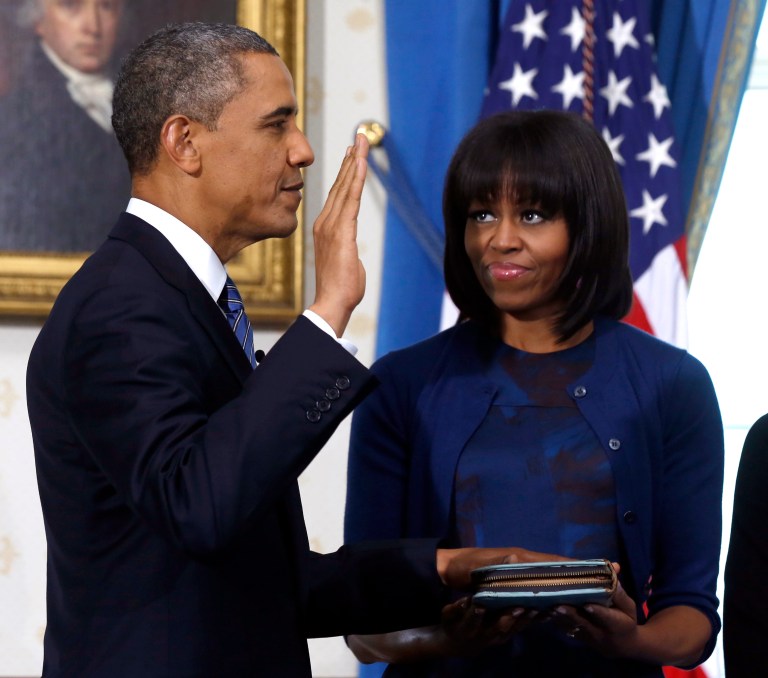 FILE - This Jan. 20, 2013 file-pool photo shows President Barack Obama officially sworn-in by Chief Justice John Roberts, not pictured, in the Blue Room of the White House in Washington, Sunday, Jan. 20, 2013, as first lady Michelle Obama, holds the Robinson Family Bible. It was a moment for Barack Obama to savor. His second inaugural address over, Obama paused as he strode from the podium last January, turning back for one last glance across the expanse of the National Mall, where a supportive throng stood in the winter chill to witness the launch of his new term. 