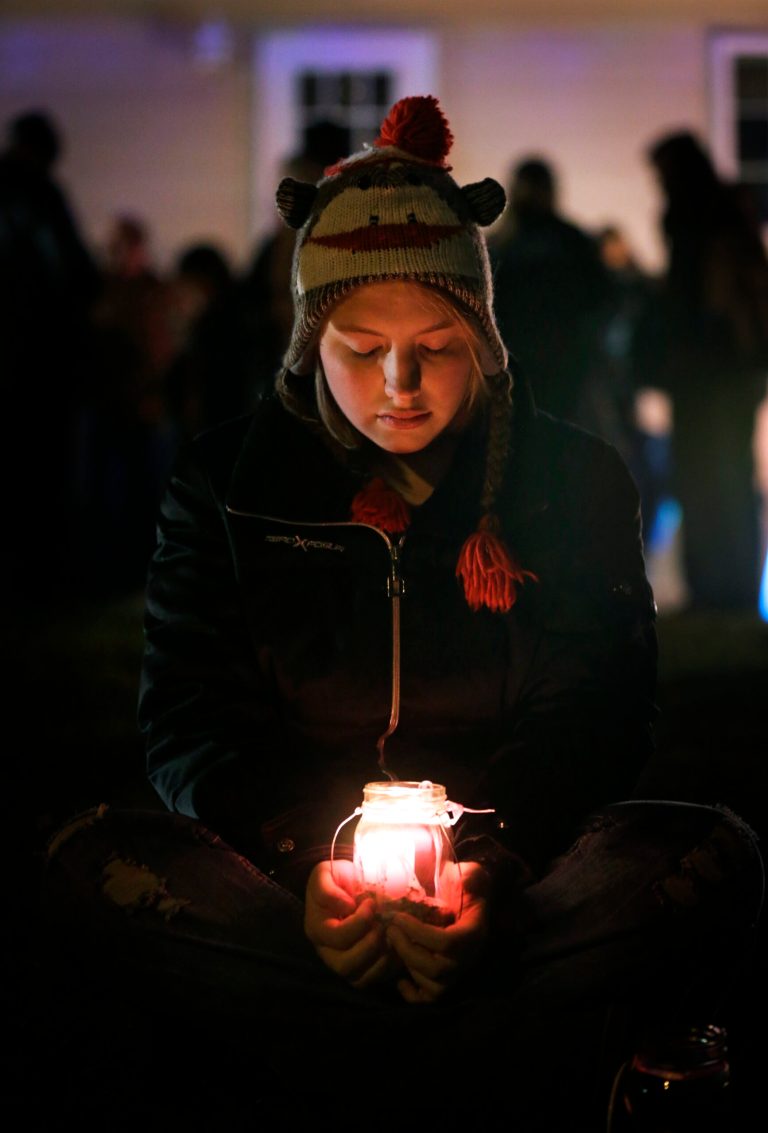   Micayla Weber, of Waterloo, Iowa, holds a candle during a vigil for missing cousins Lyric Cook, 10, and Elizabeth Collins, 8, who vanished while riding bikes in Evansdale in July, Thursday, Dec. 6, 2012, in Evansdale, Iowa. Authorities announced Thursday they are confident bodies found in an isolated wildlife area are those of the two girls. (AP Photo/Charlie Neibergall)  
