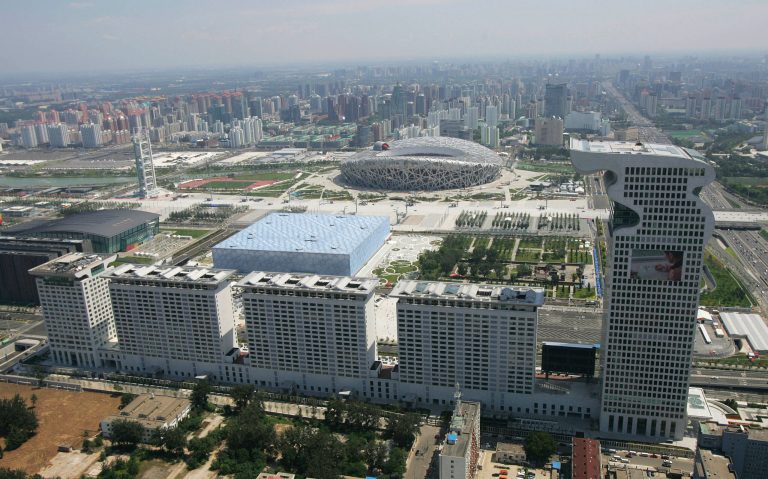 In this Saturday, Aug. 2, 2008 file photo, an aerial photo reviewed by the Chinese military, the dragon-shaped Pangu Plaza, foreground builds in front of the National Aquatics Center, known as the Water Cube, center, and the National Stadium, known as the Bird's Nest, at rear, in Beijing, China. A Beijing property developer said Saturday it has terminated cooperation with the new âTransformersâ movie, wants Paramount Pictures to make edits to it and is asking China to suspend screenings of the blockbuster film. The company owns the Pangu Plaza, a dragon-shaped hotel, office and mall complex that stretches the length of half a dozen football fields and is featured in âTransformers: Age of Extinction,â the latest installment of the hit franchise. (AP Photo/Greg Baker, File)