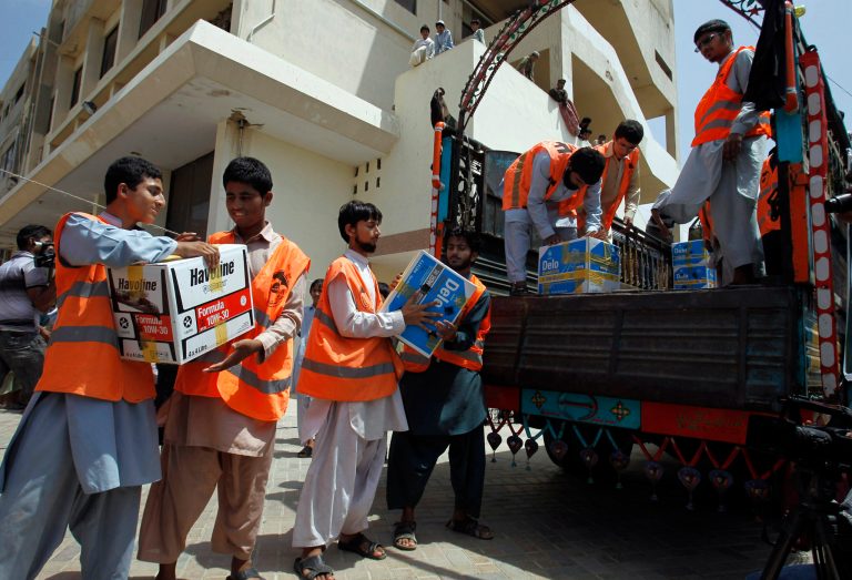 Members of an Islamic charity group Falah-i-Insaniat Foundation, load relief goods on to a truck going to flood affected areas, in Karachi, Pakistan, Sunday, Sept. 14, 2014. Civil and military officials have been using helicopters and boats to evacuate marooned people since Sept. 3, when floods triggered by monsoon rains hit Pakistan and Kashmir, which is divided between Pakistan and neighboring India. Hundreds of people have died in the flooding. (AP Photo/Fareed Khan)