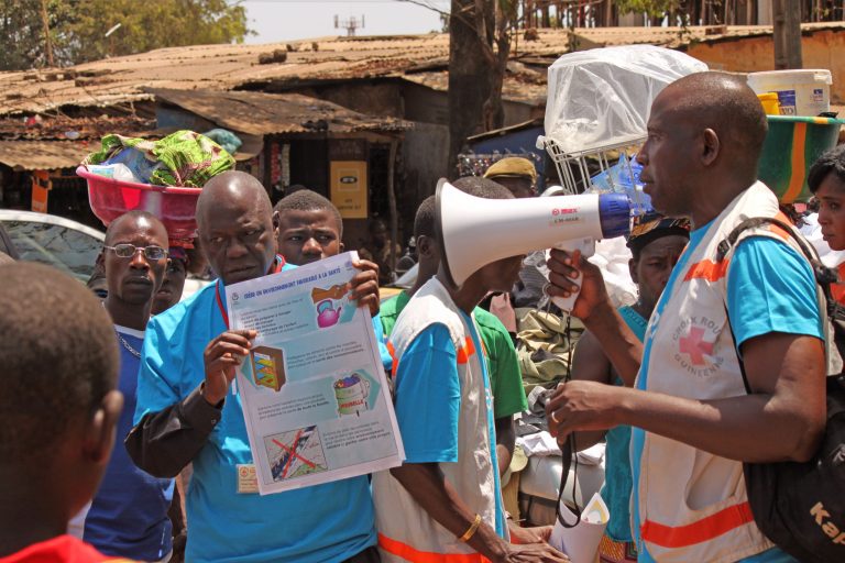 Health workers teach people about the Ebola virus and how to prevent infection,  in Conakry, Guinea, Monday, March 31, 2014. Health authorities in Guinea are facing an 