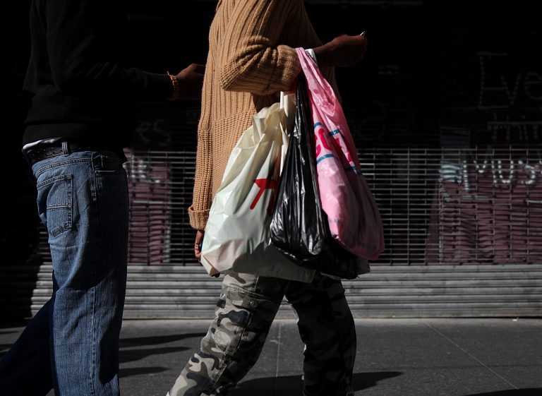   FILE- In this May 6, 2012, file photo, shoppers carry their purchases along 33rd Street in New York. U.S. retail sales declined in April and May, pulled down by a sharp drop in gas prices. But even after excluding volatile gas sales, consumers increased their spending only modestly. (AP Photo/CX Matiash, File)  