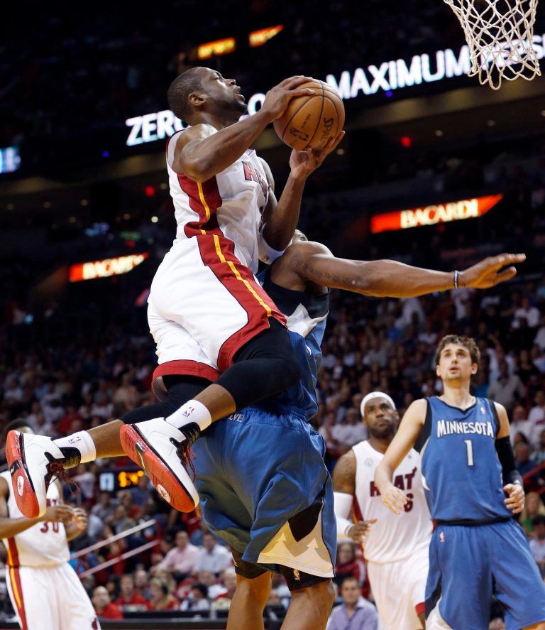   Miami Heat's Dwyane Wade, foreground, is fouled by Minnesota Timberwolves' Dante Cunningham as Wade goes to the basket during the half of an NBA basketball game Tuesday, Dec 18, 2012, in Miami. (AP Photo/Alan Diaz)  