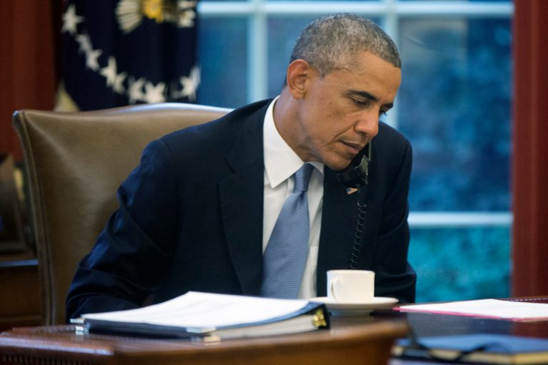 In this image made through a window of the Oval Office, President Barack Obama speaks on the phone to Saudi Arabia's King Abdullah from his desk at the White House in Washington, Wednesday, Sept. 10, 2014, ahead of his address to the nation tonight regarding Iraq and Islamic State group militants. (AP Photo/Charles Dharapak)
