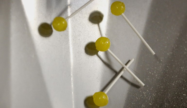 Drugs, despair, and sugar: Americans’ lifespans keep on shrinking Yellow lollipops spill out of a cooling machine during production in Ohio.