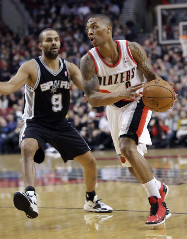   Portland Trail Blazers guard Damian Lillard, right, drives past San Antonio Spurs guard Tony Parker during the first quarter of an NBA basketball game in Portland, Ore., Thursday, Dec. 13, 2012. (AP Photo/Don Ryan)  