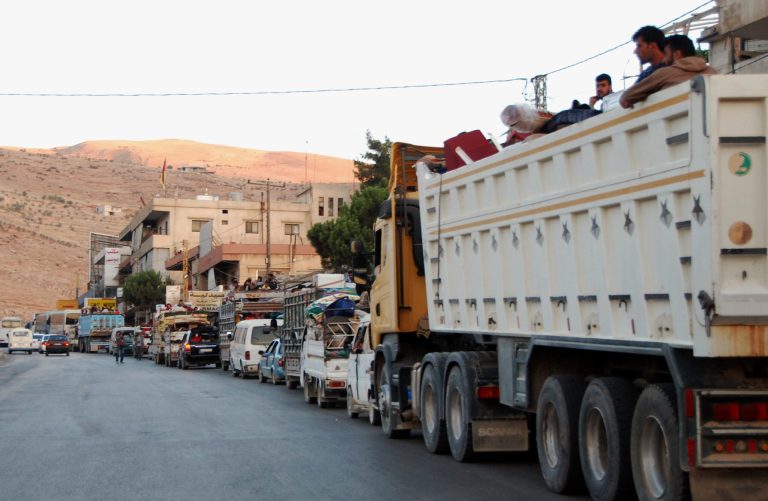 Syrian refugees flee from the Lebanese eastern town of Arsal on their way to cross back into Syria, as they ride in vehicles with their belongings at the Lebanese border crossing point of Masnaa, eastern Bekaa Valley, Lebanon, Thursday, Aug. 7, 2014. Up to 150 cars packed with Syrian refugees were seen leaving Arsal. A security official in eastern Lebanon said arrangements were made for them to cross back into Syria through the border crossing. It was not immediately clear where in Syria the refugees were going, but many may have been fleeing the violence in Arsal for areas inside their country where there has been less fighting recently. (AP Photo)