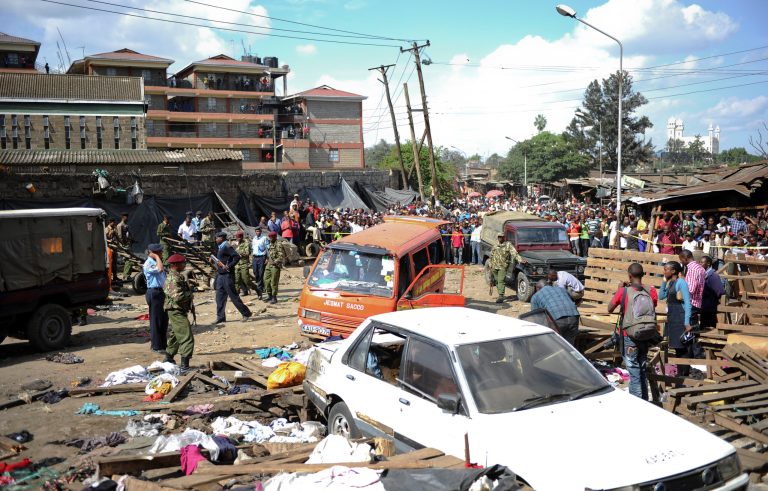 Security forces secure the scene at the site where two blasts detonated, one in a mini-van used for public transportation, in a market area of Nairobi, Kenya Friday, May 16, 2014. Two blasts hit Kenya's capital on Friday, killing a number of people and injuring many more, in what appeared to be the latest in a string of increasingly frequent terror attacks. (AP Photo)
