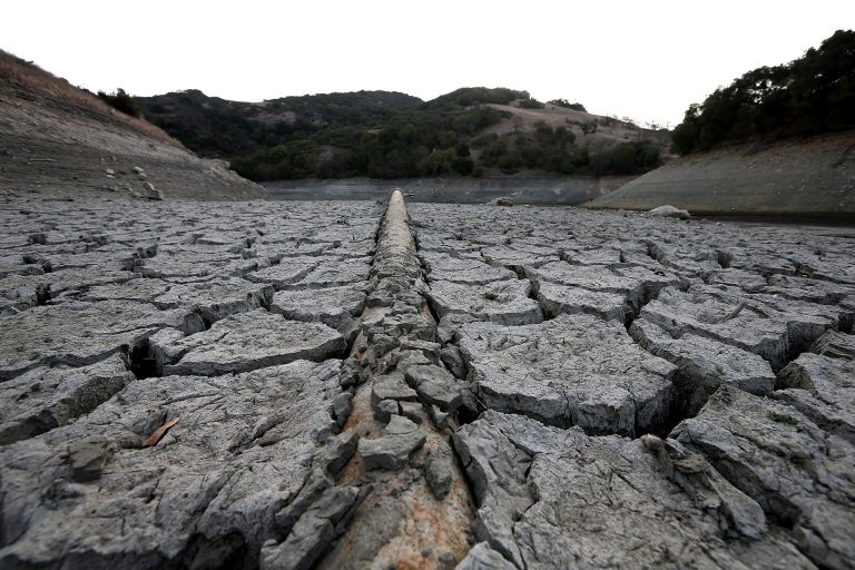 A pipe emerges from dried and cracked earth that used to be the bottom of the Almaden Reservoir on January 28, 2014 in San Jose, California. (Photo by Justin Sullivan/Getty Images)