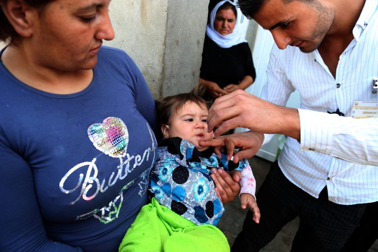 An Iraqi internally displaced Yazidi child receives a polio vaccine at the town of Khanke, outside Dahuk, 260 miles (430 kilometers) northwest of Baghdad on Sunday, Aug. 17, 2014. The Yazidis are a centuries-old religious minority viewed as apostates by the Islamic State group, which has claimed mass killings of its opponents in Syria and Iraq. Tens of thousands of Yazidis fled earlier this month when the Islamic State group captured the town of Sinjar, near the Syrian border. (AP Photo/Khalid Mohammed)
