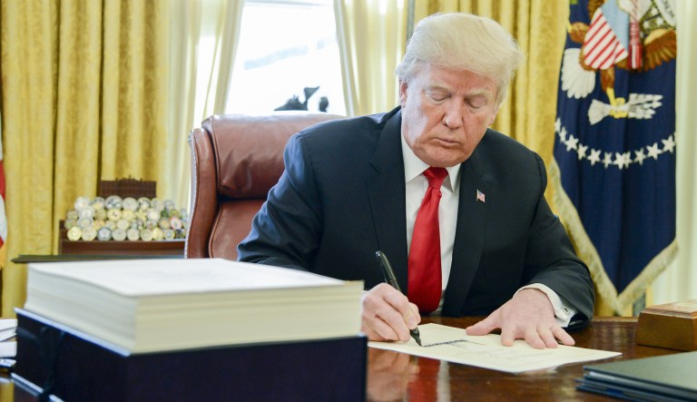 President Trump signs a tax-overhaul bill into law in the Oval Office of the White House on Friday, Dec. 22, 2017.