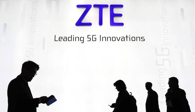 Attendees pass by the ZTE Corp. stand during the opening day of the Mobile World Congress in Barcelona, Spain, on Feb. 26, 2018.