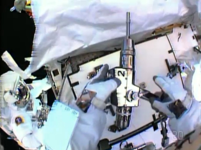 In this image made from video provided by NASA, astronaut Christopher Cassidy, foreground, holds a power wrench as he stows away a suspect coolant pump on the International Space Station on Saturday, May 11, 2013. Thomas Marshburn is at left. The two astronauts made the spacewalk to replace the pump after flakes of frozen ammonia coolant were spotted outside the station on Thursday. (AP Photo/NASA)