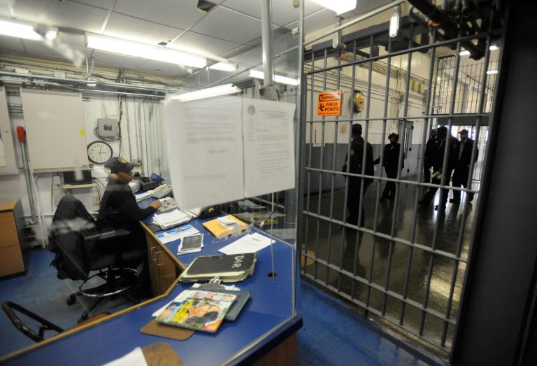 FILE - In this Nov. 14, 2013 file photo, a corrections officer works at a security post at Baltimore City Detention Center in Baltimore. Maryland Gov. Martin O'Malley planned to unveil a new cellphone security system Friday, Feb. 7, 2014, at the Baltimore City Detention Center. The technology automatically blocks calls from all cellphones inside the building, except a small number of phones assigned to employees. It also allows any phone to call 911. (AP Photo/Steve Ruark, File)