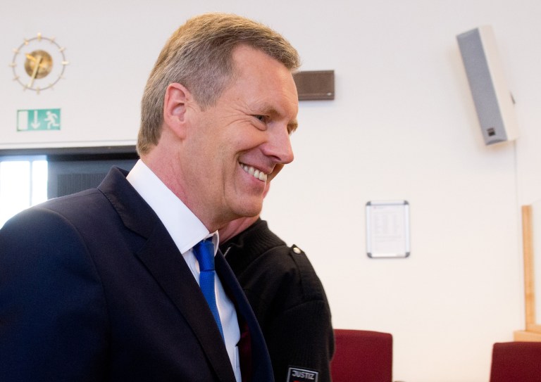 Former German President Christian Wulff smiles as he arrives for his trial at a regional court in Hannover, Germany, Thursday, Feb. 27, 2014. Germany's former president, Christian Wulff, has been acquitted over corruption allegations that prompted his resignation two years ago. Wulff quit in February 2012 following allegations he received a favorable loan and hotel stays from friends when he was governor of the state of Lower Saxony before becoming president in 2010. (AP Photo/Julian Stratenschulte, Pool)