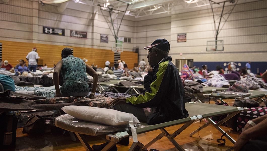 A resident sits on a cot at an evacuation shelter ahead of Hurricane Florence at the Southeast Raleigh High School in Raleigh, N.C.