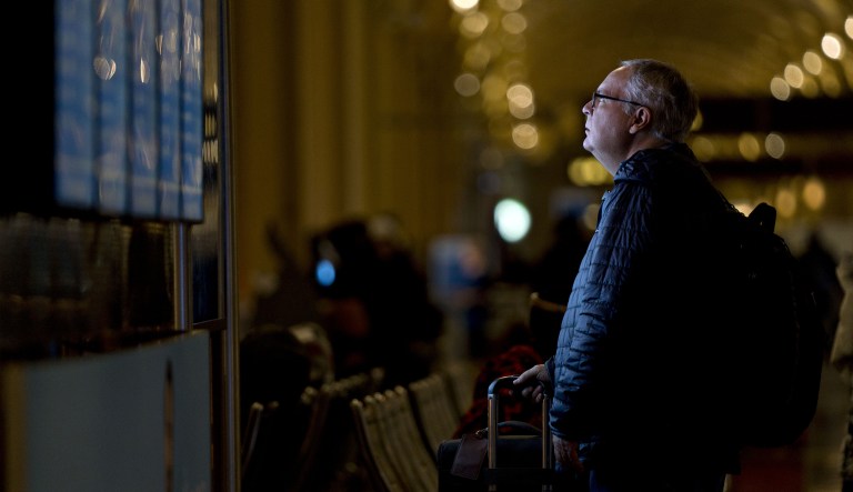 A traveler looks at an informational board at Ronald Reagan National Airport (DCA) in Washington, D.C., U.S., on Wednesday, Nov. 21, 2018.