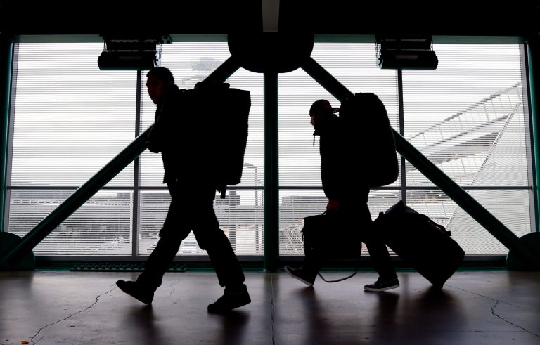   FILE - This Dec. 21, 2012 file photo shows travelers walking to a ticketing desk at O'Hare International Airport in Chicago. For many passengers, air travel is only about finding the cheapest fare. But as airlines offer a proliferating list of add-on services, from early boarding to premium seating and baggage fees, the ability to comparison-shop for the lowest total fare is eroding. (AP Photo/Nam Y. Huh, File)  