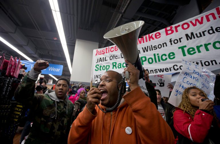 Eugene Puryear calls for a living wage and justice for Mike Brown as protesters storm Walmart, in Washington, Tuesday, Nov. 25, 2014. A grand jury in Ferguson, Mo., on Monday, Nov. 24th, 2014, declined to indict a white police officer in the shooting death of an unarmed African-American man. (AP Photo/Carolyn Kaster)