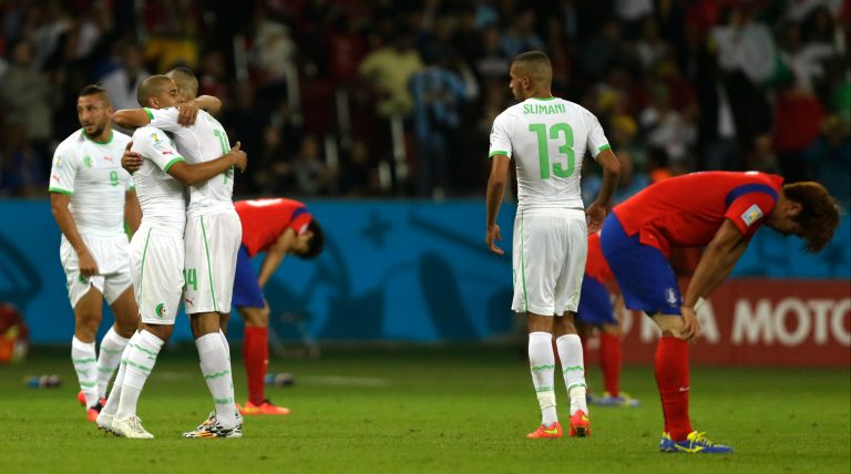 Algerian players embrace as South Korean players bow their heads after the group H World Cup soccer match between South Korea and Algeria at the Estadio Beira-Rio in Porto Alegre, Brazil, Sunday, June 22, 2014. Algeria won the match 4-2. (AP Photo/Fernando Vergara)
