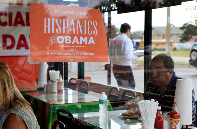 Spanish-language campaign signs promoting President Obama hang on the windows at Lechonera El Barrio Restaurant in Orlando, Fla., in October 2012. (AP Photo/Julie Fletcher)