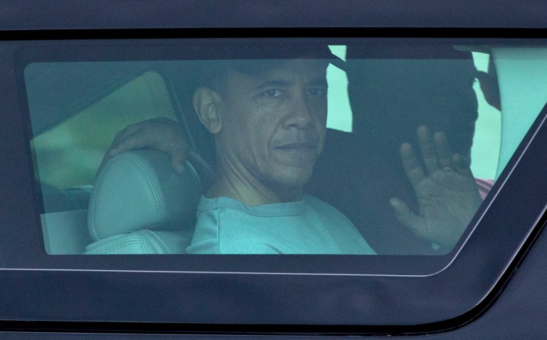   President Barack Obama waves from the window of his motorcade vehicle as he returns from a workout at Marine Corp Base Hawaii, Monday, Dec. 24, 2012, in Kailua, Hawaii. The president and the first family are in Hawaii for a family holiday vacation. (AP Photo/Carolyn Kaster)  
