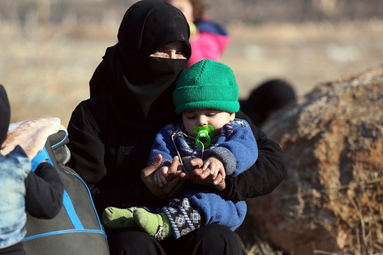 A Syrian woman holding a child, who were evacuated from the embattled Syrian city of Aleppo during the cease-fire, arrive at a refugee camp in Rashidin, near Idlib, Syria, early Monday, Dec. 19, 2016. (AP Photo)