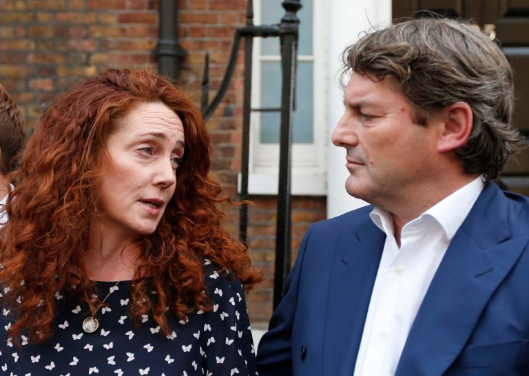 Rebekah Brooks, left, former News International chief executive, looks at her husband Charlie, right, as she talks to members of the media in central London, Thursday, June 26, 2014. Brooks was acquitted after a long trial centering on illegal activity at the heart of Rupert Murdoch's newspaper empire but Former News of the World editor Andy Coulson was convicted of phone hacking. The nearly eight-month trial was triggered by revelations that for years the News of the World used illegal eavesdropping to get stories, listening in on the voicemails of celebrities, politicians and even crime victims. (AP Photo/Lefteris Pitarakis)