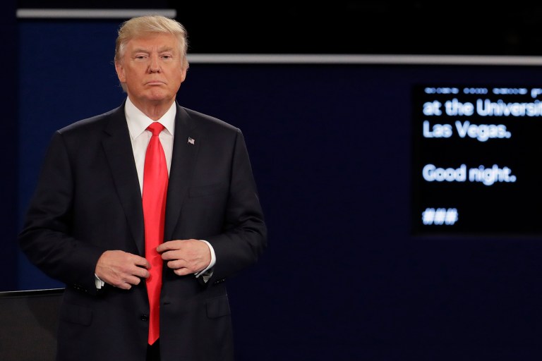 Republican presidential nominee Donald Trump buttons his jacket after the second presidential debate at Washington University in St. Louis, Sunday, Oct. 9, 2016. (AP Photo/Julio Cortez)