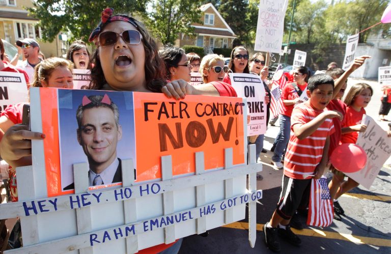 Striking Chicago Public School teachers picket as Mayor Rahm Emanuel visits with students in Chicago in September 2012. (AP Photo/M. Spencer Green, File)