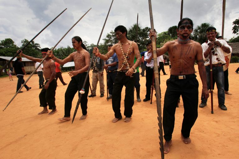 FILE - In this Aug. 12, 2012 file photo, Sarayaku Indian men dance during celebrations in Sarayaku village in Ecuador. Ecuador's President Rafael Correa threatened unspecified consequences Tuesday, April 29, 2014 for the fiercely independent indigenous community in Ecuador's Amazon that is harboring three political opponents who face prison for defaming him. The remote community is famed among the indigenous in the Americas for successfully resisting oil drilling. (AP Photo/Dolores Ochoa, File)