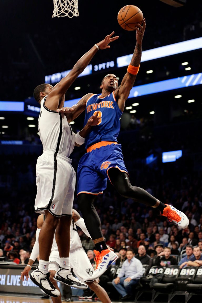   New York Knicks guard J.R. Smith (8) shoots as Brooklyn Nets guard Joe Johnson (7) defends in the first half of their NBA basketball game at Barclays Center, Tuesday, Dec. 11, 2012, in New York. (AP Photo/Kathy Willens)  