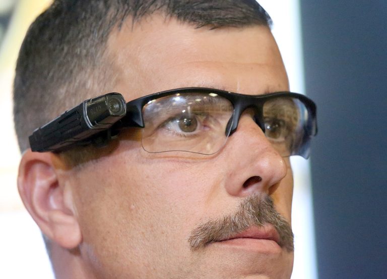 Project manager Sheriff's Lt. Chris Marks displays a camera at a news conference at the Sheriff's Headquarters in the Monterey Park section of Los Angeles on Monday, Sept. 22, 2014. Dozens of sheriff's deputies at selected stations in Los Angeles County are testing body cameras during a six-month pilot program, officials said Monday. (AP Photo/ Nick Ut)