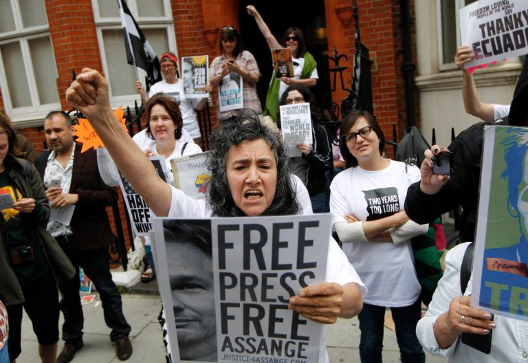 Supporters of WikiLeaks founder Julian Assange hold a vigil outside the Ecuadorian Embassy in London to mark his two years in refuge at the embassy, Thursday, June 19, 2014. Julian Assange entered the embassy in June 2012 to gain political asylum to prevent him from being extradited to Sweden, where he faces allegations of sex crimes, which he denies.(AP Photo/Sang Tan)